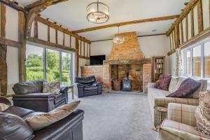 a living room with leather furniture and a stone fireplace at 5 Bed in Roxwell oc-t30824 in Roxwell