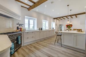a large kitchen with white cabinets and a kitchen island at 5 Bed in Roxwell oc-t30824 in Roxwell