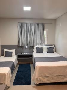 a bedroom with two beds and a window at PARIS HOTEL in Barreiras