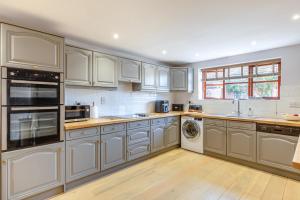 a kitchen with white cabinets and a washer and dryer at 4 Bed in Burrowbridge oc-o33020 in Athelney