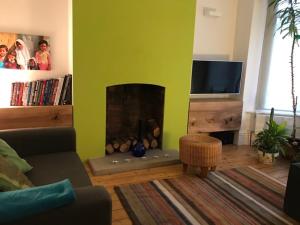 a living room with a fireplace and a tv at Stunning 3 bed house by Endcliffe Park in Nether Edge