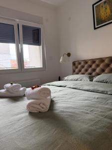 a bedroom with two towels sitting on a bed at PRESTIGE apartman Krusevac in Kruševac