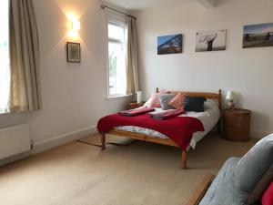 a bedroom with a bed with a red blanket on it at Stunning 3 bed house by Endcliffe Park in Nether Edge