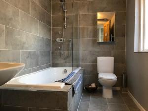 a bathroom with a tub and a toilet and a sink at Stunning 3 bed house by Endcliffe Park in Nether Edge +21 photos