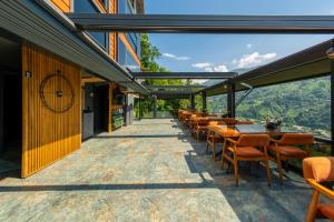 a restaurant with tables and chairs on a patio with a view at Pavri suit bungalov in Ardeşen