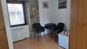 a room with three black chairs and a window at Rooms Svalina in Grožnjan