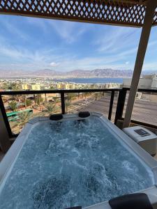 a hot tub on a balcony with a view of the ocean at Kohav Sea View Penthouse in Eilat