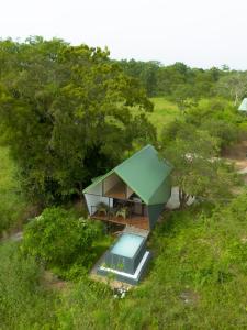 a green house with a swimming pool in a field at VerdEra Wild - Wilpattu in Wilpattu