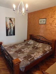 a bedroom with a bed with a painting on the wall at Sweet Dream Rooms in Podgorica