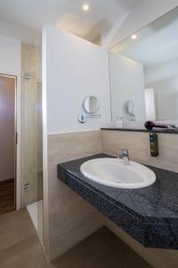 een badkamer met een wastafel en een spiegel bij Hotel-Restaurant Dimmer - Mullerthal in Wallendorf pont +93 foto's