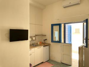 eine Küche mit Spüle und einem Fernseher an der Wand in der Unterkunft Punta San Simone in Marettimo + 1 Foto