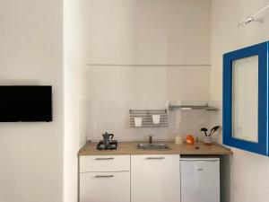 eine Küche mit Spüle und einem Fernseher an der Wand in der Unterkunft Punta San Simone in Marettimo