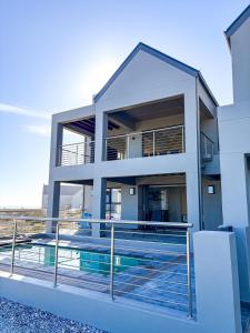 a house with a swimming pool in front of it at Casa Costeira in Britannia Bay