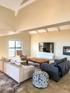 a living room with two couches and a table at Casa Costeira in Britannia Bay +79 photos