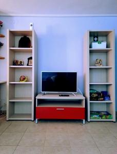 a tv sitting on a table in a room with shelves at Home4you in Skala Mistegnon