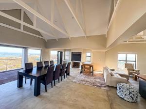 a living room with a dining room table and chairs at Casa Costeira in Britannia Bay