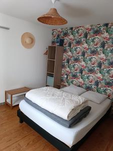 a bed in a room with a floral wallpaper at Meublé de vacances, Quend-Plage in Quend-Plage