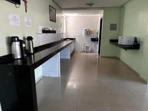 a kitchen with a counter and a toilet in a room at Hotel Realeza in Goiânia +17 photos