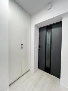 an empty room with white walls and a black door at Lubicz Dolny, A1 Apartament 2 pokojowy in Lubicz