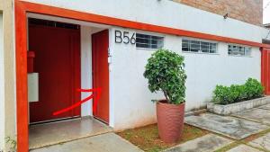 a red door and a plant in front of a building at Studio Andorinhas in Brasília