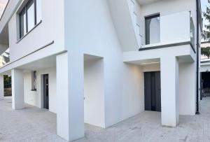 a white facade of a building with windows at Lubicz Dolny, A1 Apartament 2 pokojowy in Lubicz