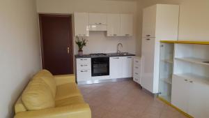 a kitchen with a yellow couch in a room at Casa Vacanze Capoterra in Capoterra