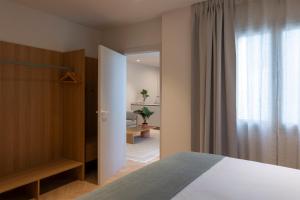 a bedroom with a bed and a closet and a window at Apartamentos Boutique Casco Histórico in Las Lagunas