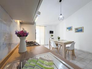 a kitchen and living room with a table and a dining room at Residenza Centrale in Villasimius