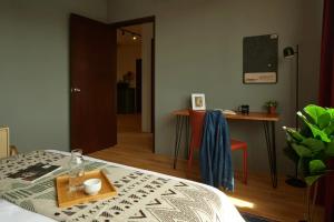 a bedroom with a bed and a table and a desk at House Rong in Singapore