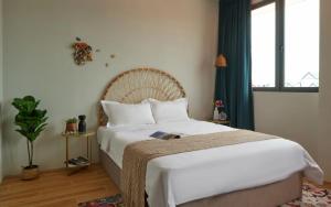 a bedroom with a large white bed and a window at House Rong in Singapore +15 photos