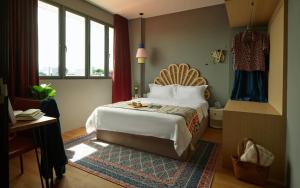 a bedroom with a bed and a desk and windows at House Rong in Singapore