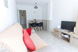 a living room with a couch and a tv and a table at 099 - Parque y playa 007 - comfortHOLIDAYS in Santa Pola