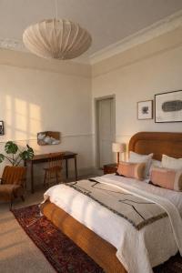 a bedroom with a large bed and a desk at Coed Mawr Hall Bed & Breakfast in Conwy