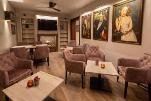 een wachtkamer met tafels en stoelen en schilderijen aan de muur bij Hotel-Restaurant Dimmer - Mullerthal in Wallendorf pont
