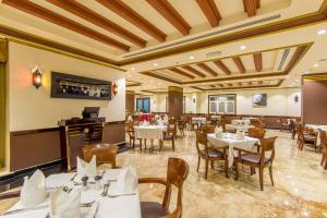 a dining room with white tables and chairs at Caesar Hotel in Muscat