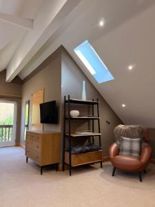 a living room with a skylight and a chair at The Stables Luxury B&B in Bury