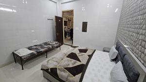 a room with two beds and a mirror in it at Kirpalu haridham hotel in Vrindāvan +2 photos