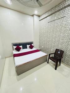 a bedroom with a bed and a chair at Kirpalu haridham hotel in Vrindāvan