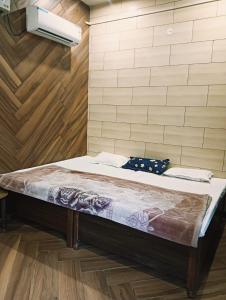 a large bed in a room with wooden floors at Kirpalu haridham hotel in Vrindāvan