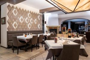 een restaurant met tafels en stoelen en een open haard bij Hotel-Restaurant Dimmer - Mullerthal in Wallendorf pont