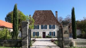 a white house with a gate in front at Le Moulin du Clapier - La Ficelle in Sorges