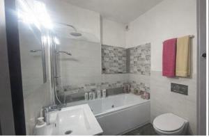 a bathroom with a tub and a toilet and a sink at Acquamarina Luxury House in Budoni
