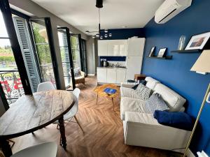 a living room with a couch and a table at Le Bristol - Gîtes Canal & Chenier, proche gare in Carcassonne