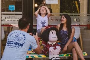 a man and a woman and a child sitting on a bed at Hotel Calimera in Santa Teresita