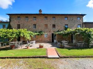 a large brick building with tables and chairs in front of it at Relais Del Lago in Capannori