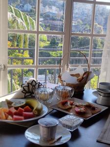 ein Tisch mit zwei Tellern Essen und einem Fenster in der Unterkunft Star Gate in Nuwara Eliya
