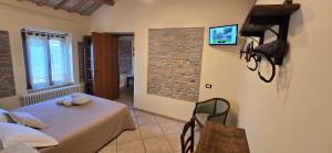 a room with a table and chairs and a brick wall at Agriturismo Papaveri e Papere in Saludecio