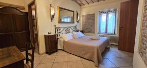a bedroom with a bed with white sheets and a mirror at Agriturismo Papaveri e Papere in Saludecio +63 photos