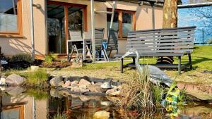 a bench sitting next to a pond in front of a house at Ferienwohnung Reuscher, Trier-Newel in Newel