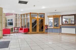 a lobby with red chairs and a glass door at The Greyhound Hotel in Leigh
